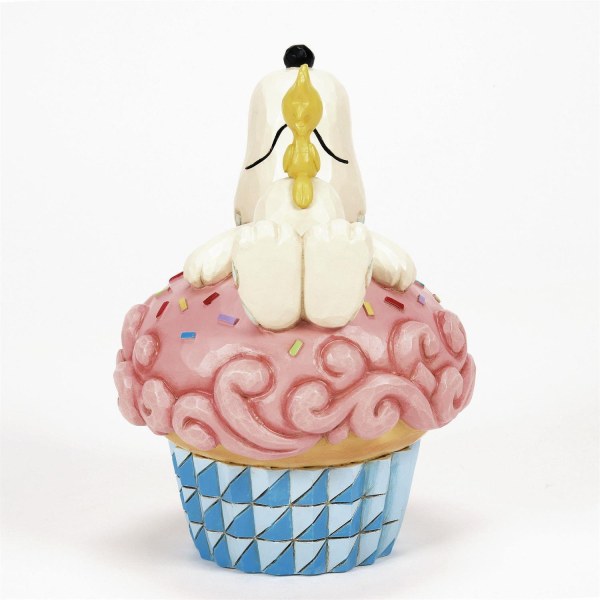 Snoopy recostado sobre un cupcake - Peanuts